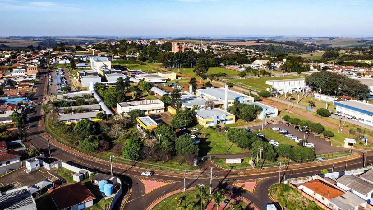 Vista aérea de um campus universitário, com prédios acadêmicos e áreas verdes ao redor.