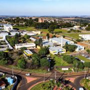 Vista aérea de um campus universitário, com prédios acadêmicos e áreas verdes ao redor.