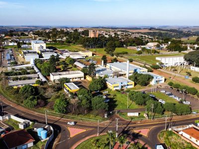 Vista aérea de um campus universitário, com prédios acadêmicos e áreas verdes ao redor.