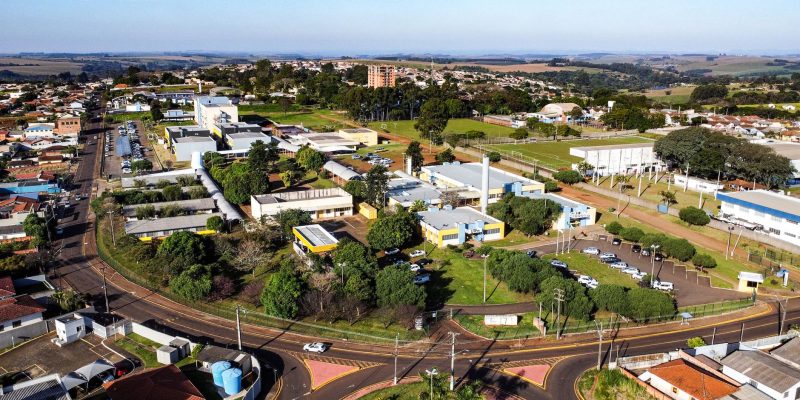 Vista aérea de um campus universitário, com prédios acadêmicos e áreas verdes ao redor.