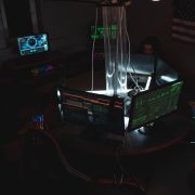 Equipe de especialistas em cibersegurança trabalhando diante de computadores em uma sala pouco iluminada.