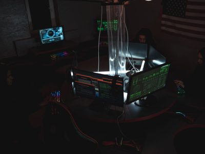 Equipe de especialistas em cibersegurança trabalhando diante de computadores em uma sala pouco iluminada.