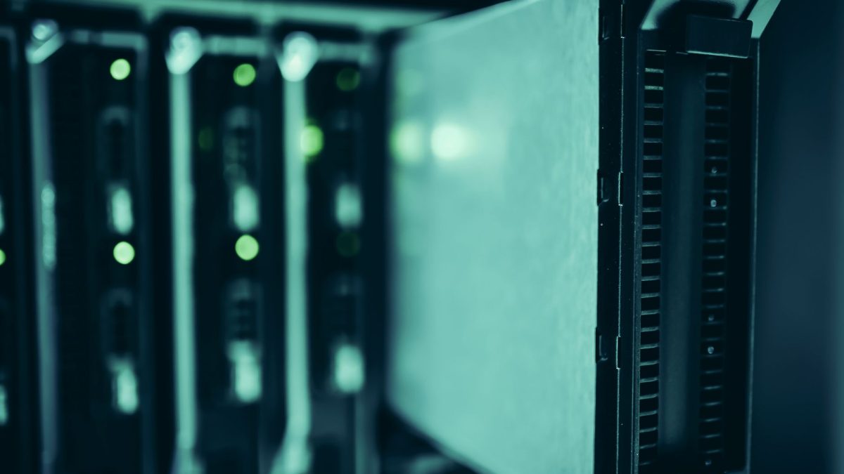Racks de servidores iluminados em azul em um data center, representando infraestrutura de computação de alto desempenho.
