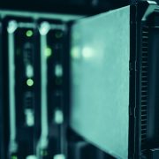Racks de servidores iluminados em azul em um data center, representando infraestrutura de computação de alto desempenho.