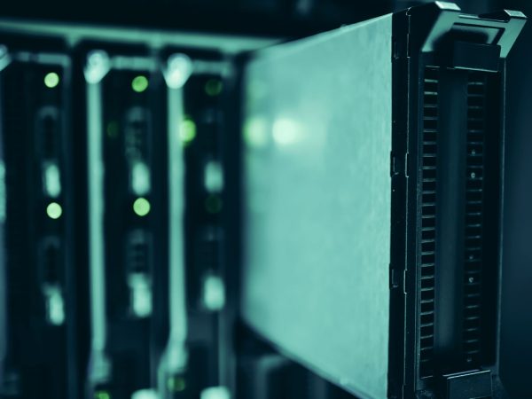 Racks de servidores iluminados em azul em um data center, representando infraestrutura de computação de alto desempenho.
