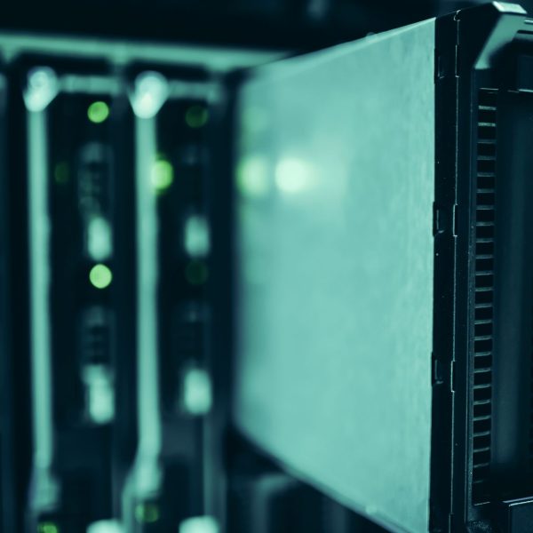 Racks de servidores iluminados em azul em um data center, representando infraestrutura de computação de alto desempenho.