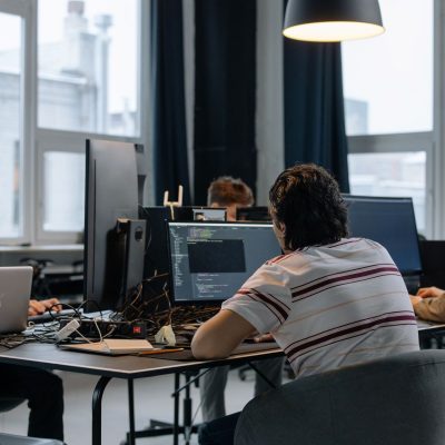 Equipe de desenvolvedores trabalha em computadores em um escritório de tecnologia.