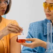 Duas cientistas seguram um frasco em um laboratório durante uma atividade de pesquisa.