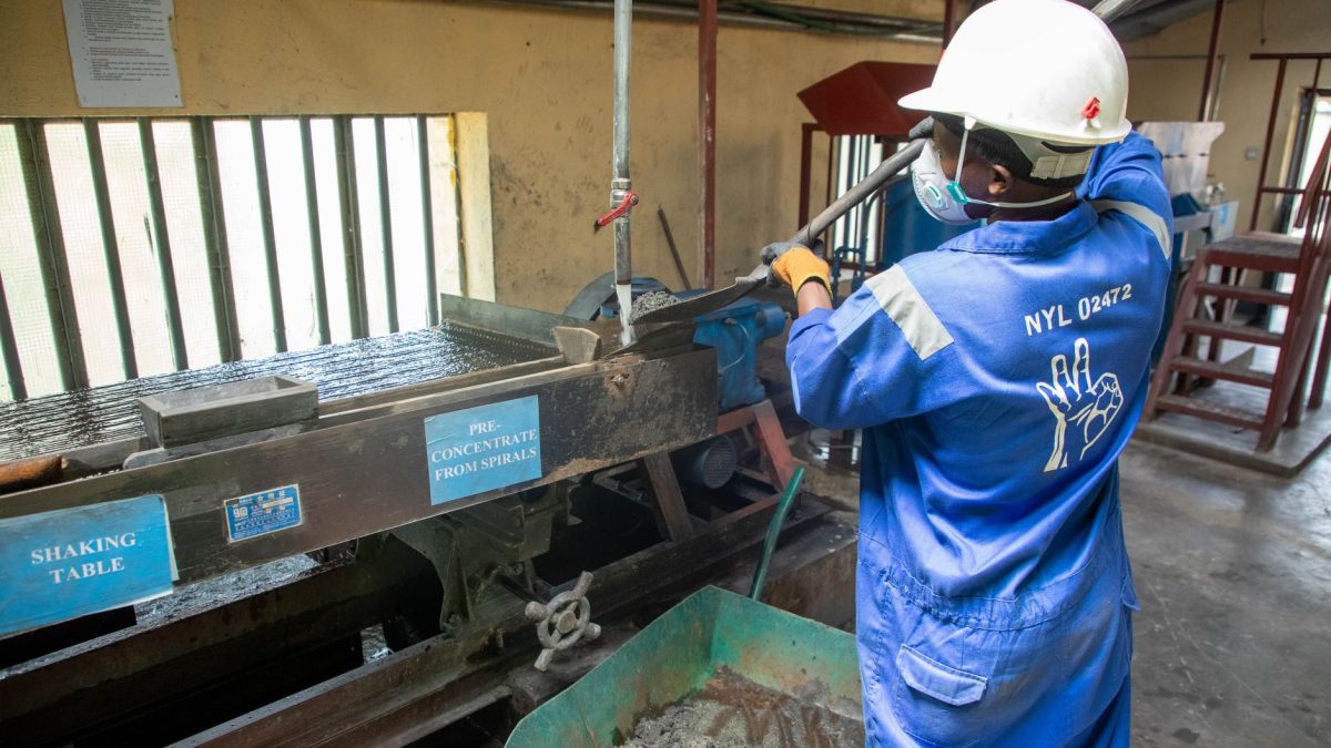 Trabalhador usando equipamento de concentração de minério em uma unidade de processamento mineral.