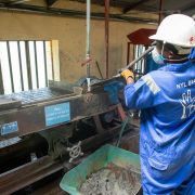Trabalhador usando equipamento de concentração de minério em uma unidade de processamento mineral.