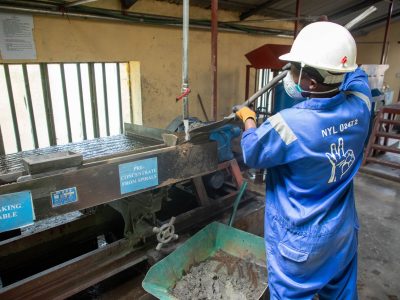 Trabalhador usando equipamento de concentração de minério em uma unidade de processamento mineral.