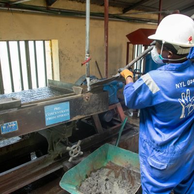 Trabalhador usando equipamento de concentração de minério em uma unidade de processamento mineral.