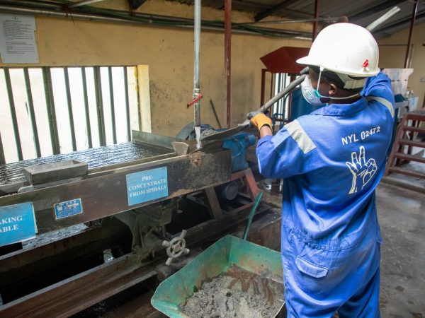Trabalhador usando equipamento de concentração de minério em uma unidade de processamento mineral.
