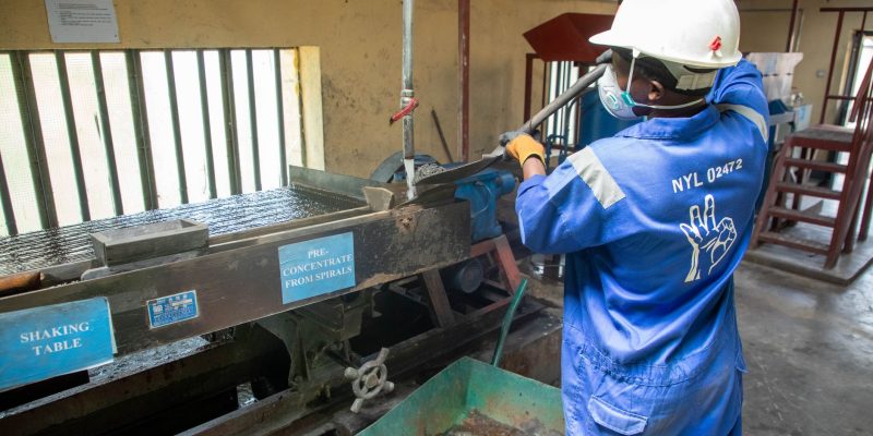 Trabalhador usando equipamento de concentração de minério em uma unidade de processamento mineral.