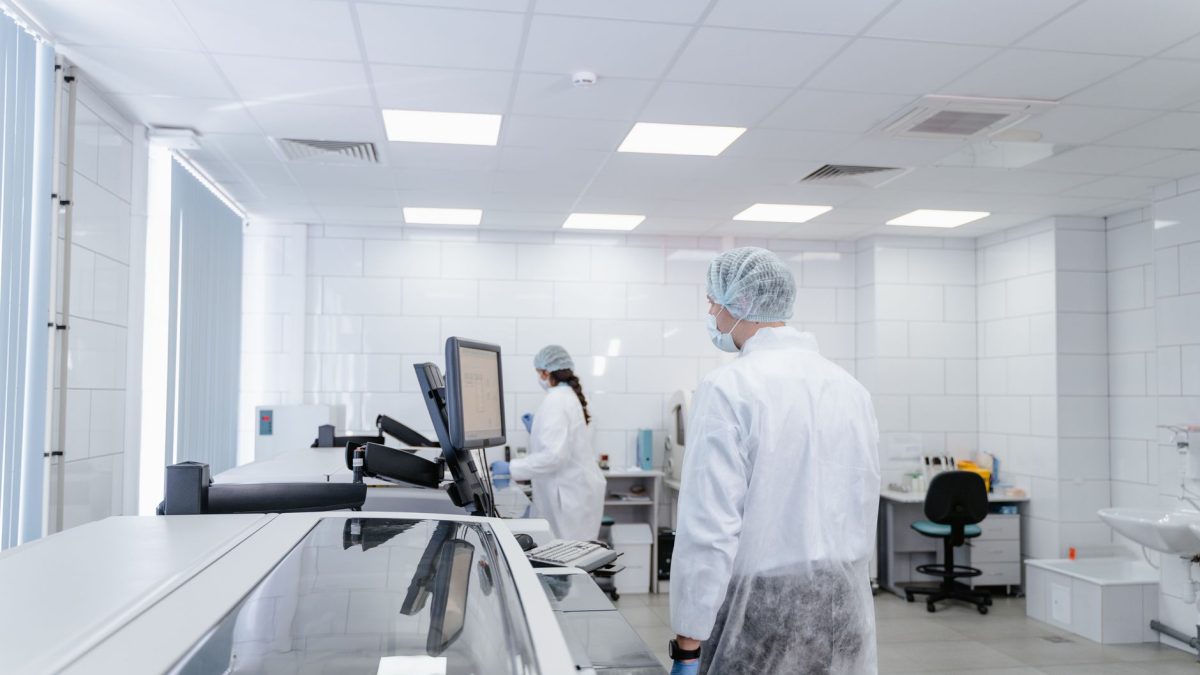 Profissionais de laboratório realizam pesquisas em um ambiente moderno e equipado.