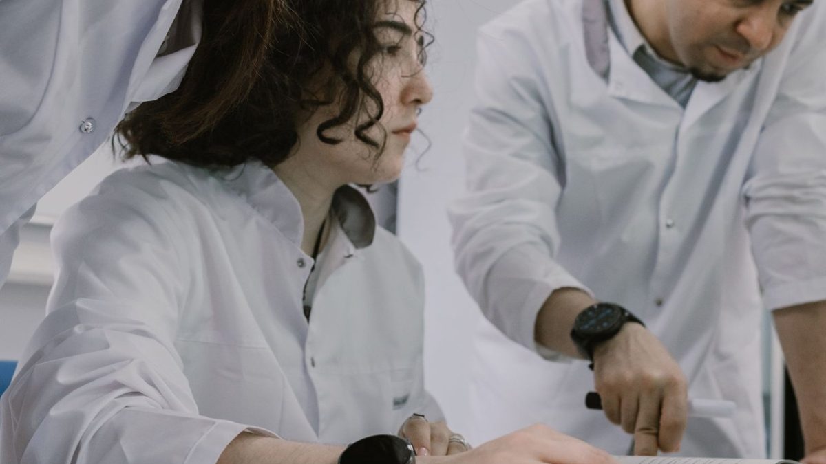 Grupo de cientistas trabalha em conjunto em um laboratório, analisando equipamentos e materiais de pesquisa.