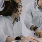 Grupo de cientistas trabalha em conjunto em um laboratório, analisando equipamentos e materiais de pesquisa.