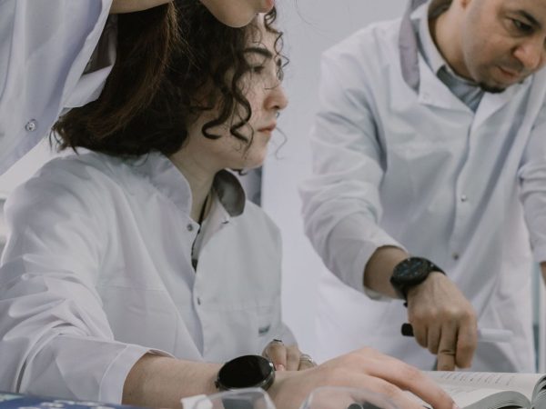 Grupo de cientistas trabalha em conjunto em um laboratório, analisando equipamentos e materiais de pesquisa.