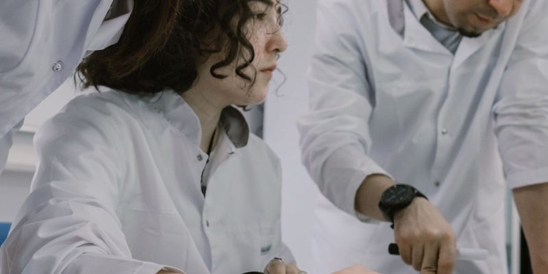Grupo de cientistas trabalha em conjunto em um laboratório, analisando equipamentos e materiais de pesquisa.
