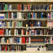 Estantes repletas de livros em uma biblioteca, representando pesquisa e produção de conhecimento.